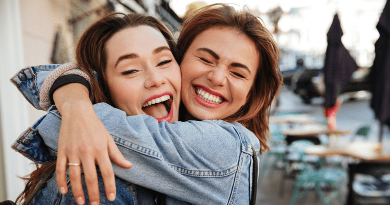 dos mujeres felices amigas abrazándose que se conocieron por aprender inglés