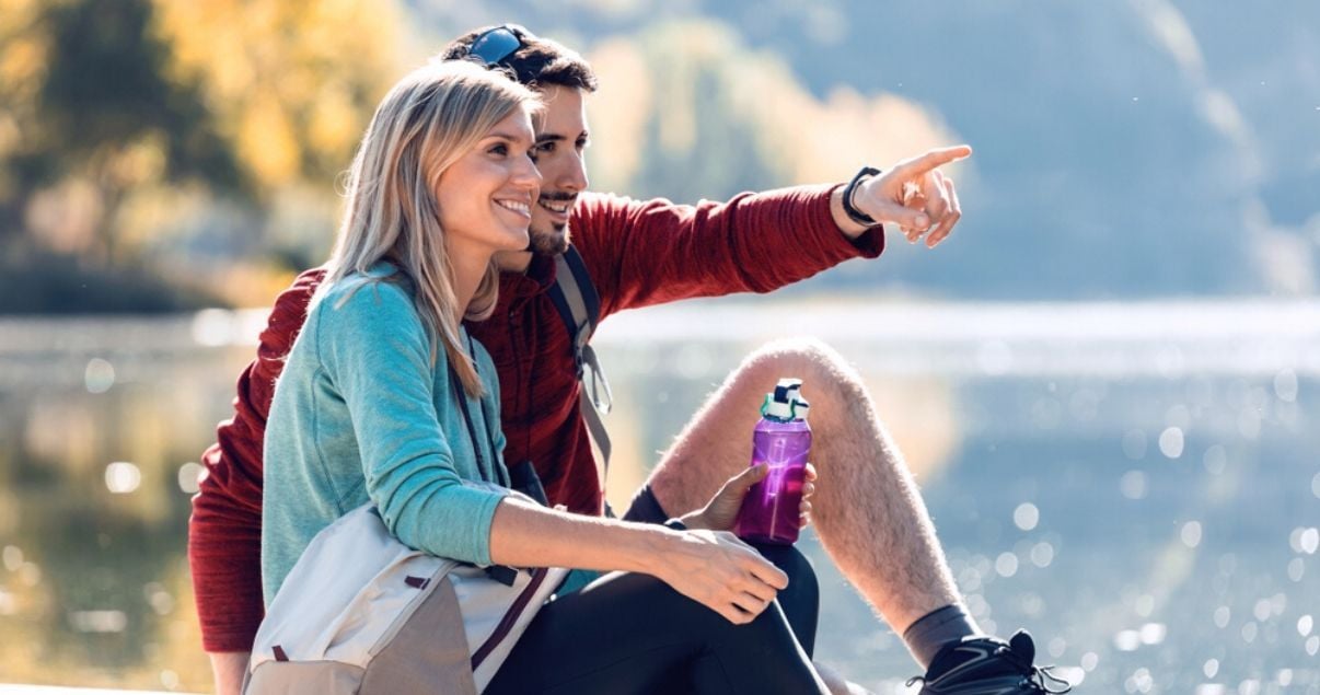 Pareja joven en un lago de vacaciones practicando los sinónimos en inglés