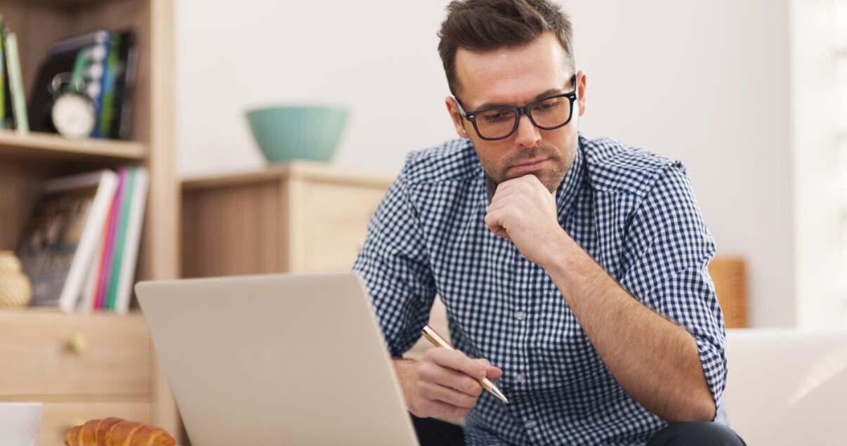 hombre con laptop pensando en aprender inglés
