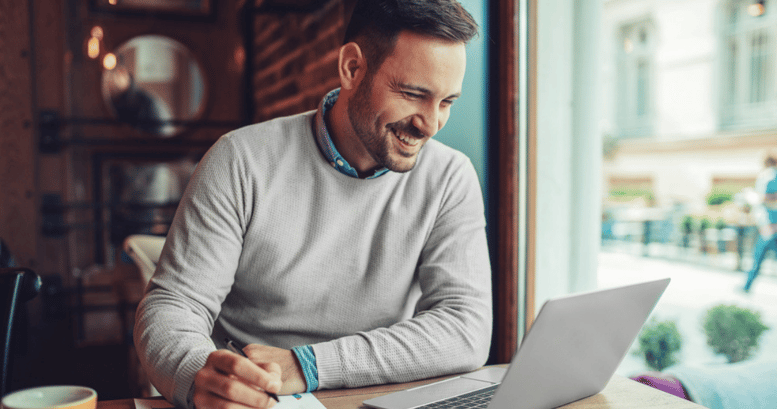 Hombre adulto en un cafe armando su carta de presentación en inglés para postularse para un nuevo trabajo.