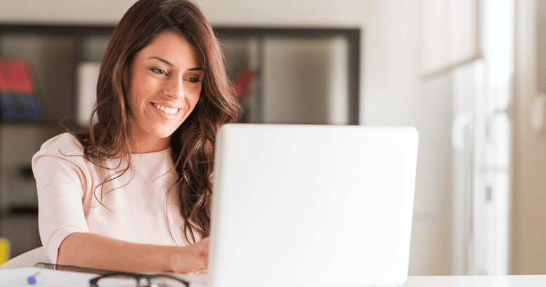 Mujer aprendiendo vocabulario en inglés feliz en su laptop con un anotador a su lado