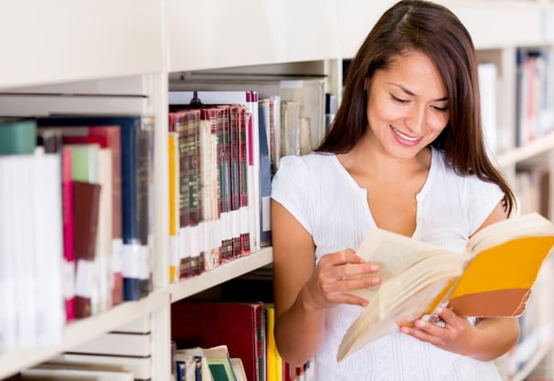 Female student at the library reading a book