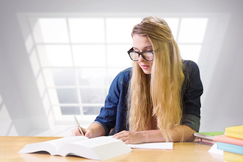 Student studying in the library against room with large window showing city