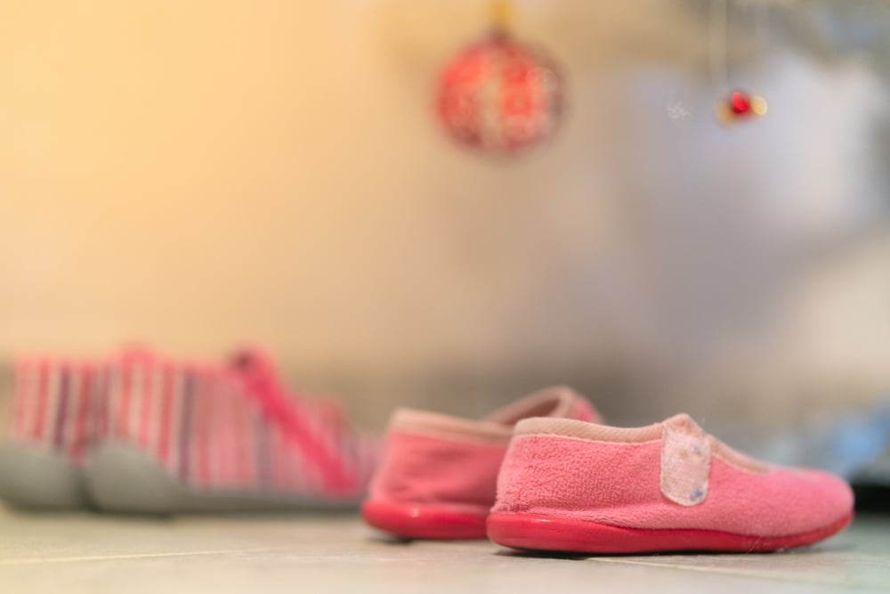 zapatos de niña debajo del arbol de navidad esperando los regalos de los reyes magos